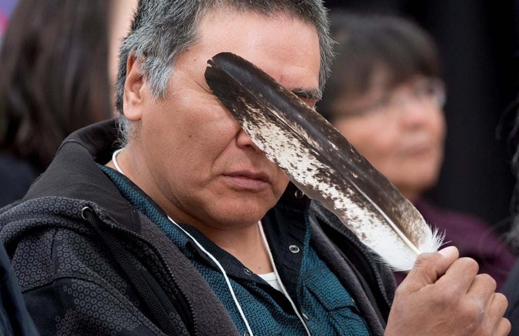 Terry Ladue holds a eagle feather to his face after speaking of his mother Jane Dick Ladue's murder at the National Inquiry into Missing and Murdered Indigenous Women and Girls taking place in Whitehorse on June 1, 2017.