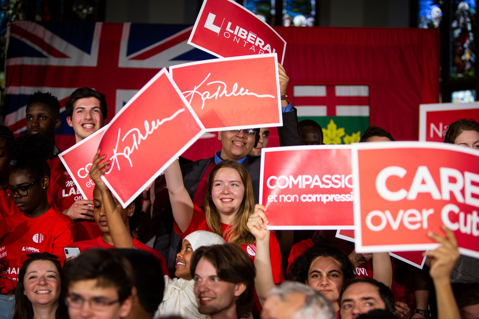 Ontario Liberal supporters hold up campaign signs, including 