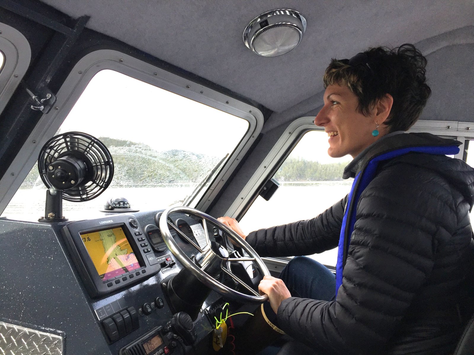 Jenn Burt at the helm of a Hakai Institute research vessel.