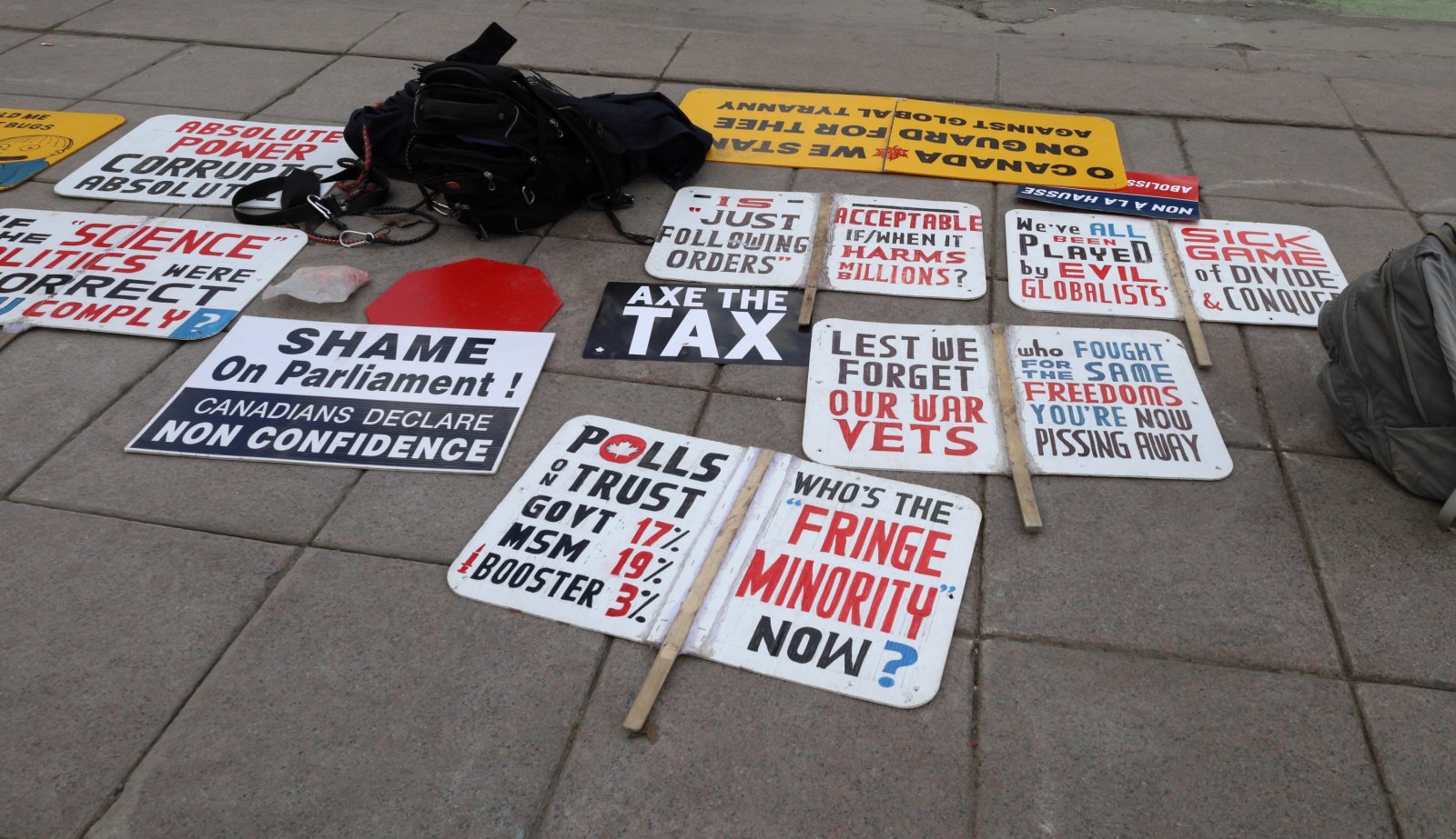 an array of signs on the ground at a carbon price protest on April 1 2024
