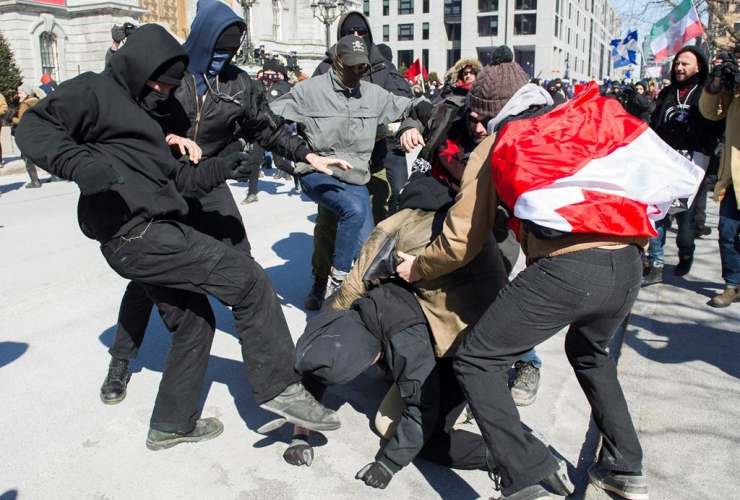 Anti-fascist protesters, left, clash with opposing protestors during a demonstration regarding motion M-103 in Montreal, Saturday, March 4, 2017.