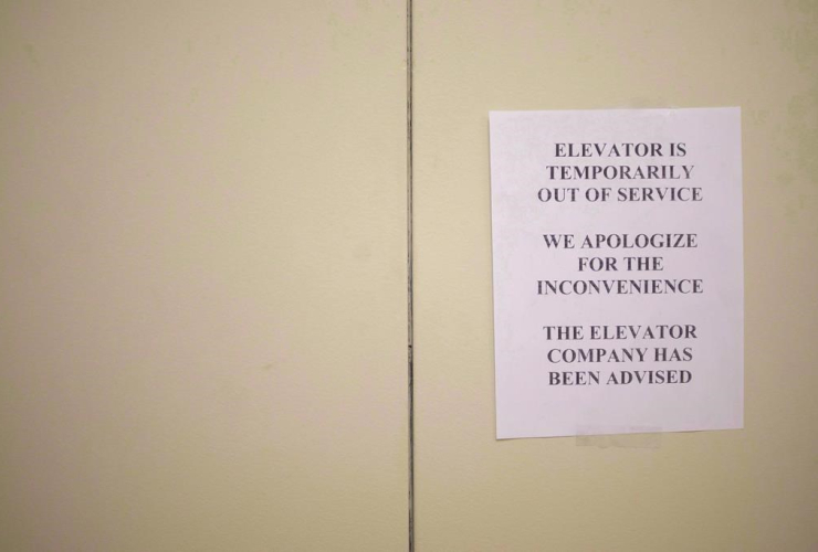 A sign is taped to a door of an elevator in a downtown Toronto office building on July 13, 2016. 