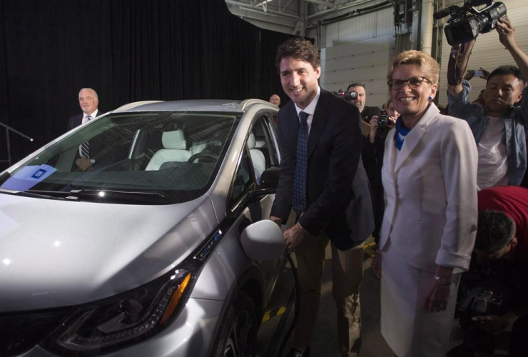 Prime Minister Justin Trudeau, left, and Ontario Premier Kathleen Wynne pose as they plug in an electric vehicle at the General Motors plant in Oshawa, Ont., in a June 10, 2016