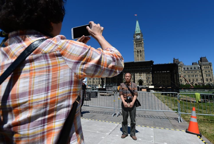 Chinese tourists vist Parliament Hill in Ottawa on Wednesday, June 14, 2017, as preparations for Canada Day are underway.