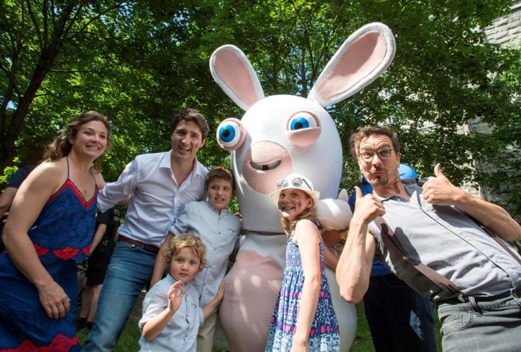 A man photo bombs a photo with Prime Minister Justin Trudeau and his family at a street party for the Fete National du Quebec, on Saturday, June 24, 2017 in Montreal.