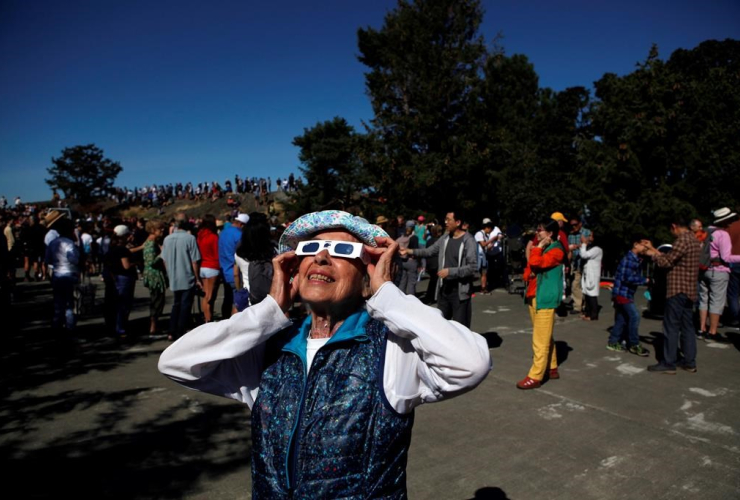 Canadians across the country put on protective glasses, glanced through solar telescopes and scrutinized pinhole projectors to take in a partial solar eclipse Monday.