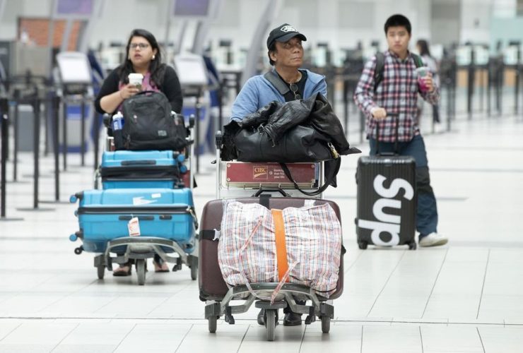 Passengers, push, luggage, departure terminal, Toronto Pearson Airport, Mississauga, Ont., 