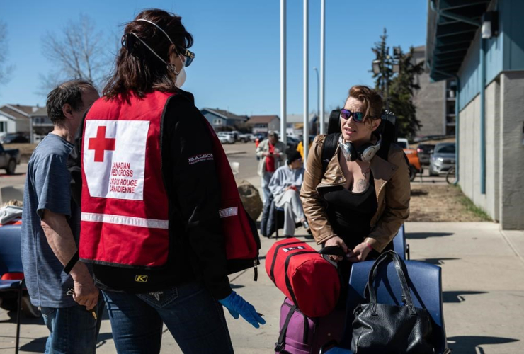 Red Cross volunteer Karen Wyonzek, registers, displaced person, Shanna Skinner, evacuee registration centre, ice arena, Thickwood Heights,