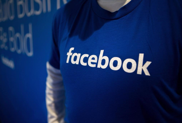 A person wearing a blue-and-white Facebook T-shirt