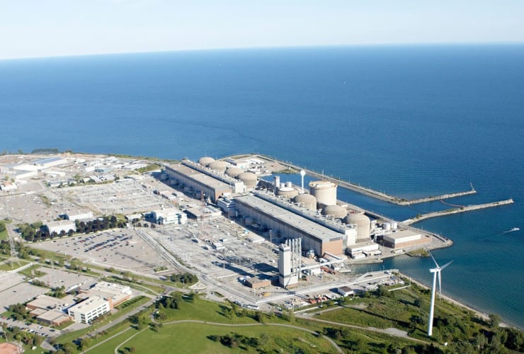 An aerial view of a nuclear power plant located by the water.