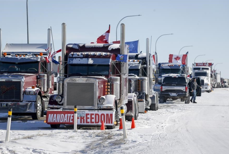 A truck convoy of anti-COVID-19 vaccine mandate demonstrators block the highway at the busy U.S. border crossing in Coutts, Alta., on Wednesday, Feb. 2, 2022. File photo by The Canadian Press/Jeff McIntosh