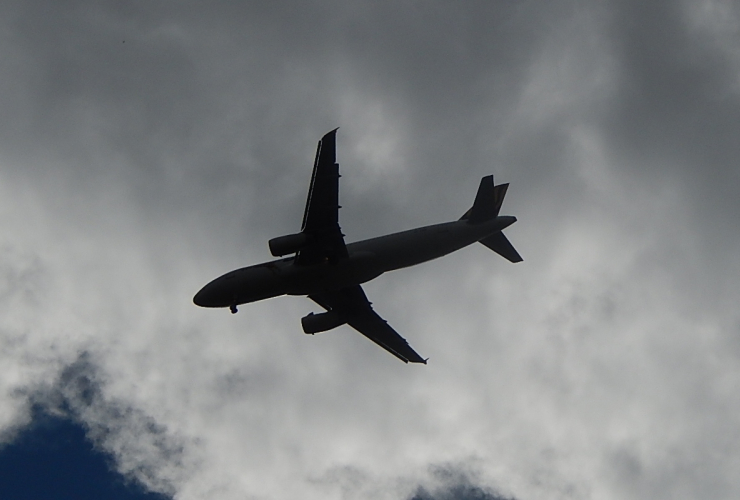 airplane silhouette against blue sky