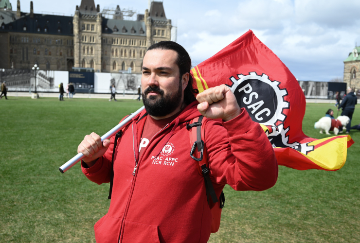 A man with a megaphone poses for a photo at Parliament Hill