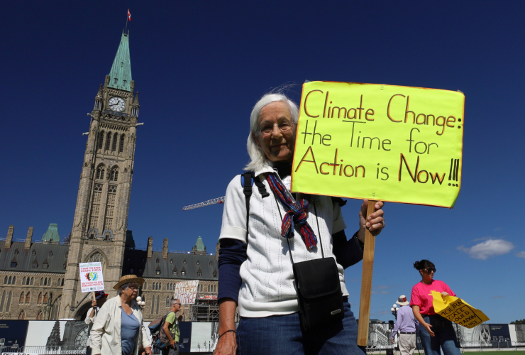 A woman attends a cliamte protest on Parliament Hill in Ottawa, Ont.