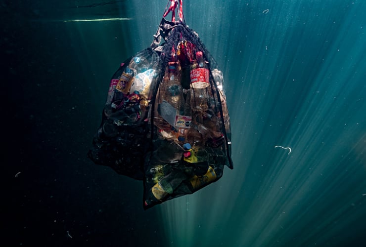 a bag of plastic garbage suspended in the water 